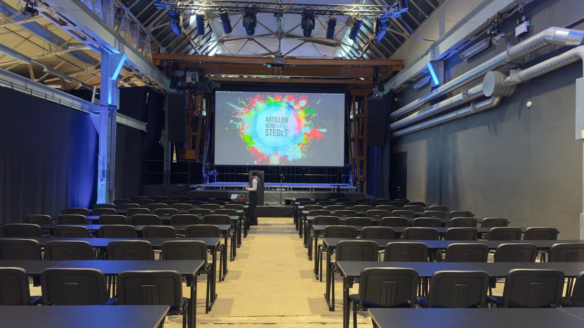 Storsalen på Artilleriverkstedet rigget til konferanse med scene og lerret